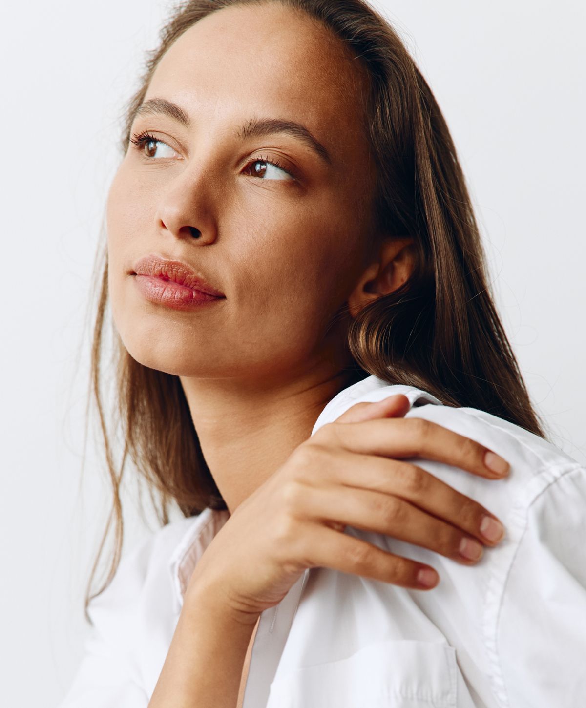 Woman with shoulder-length hair in white shirt.