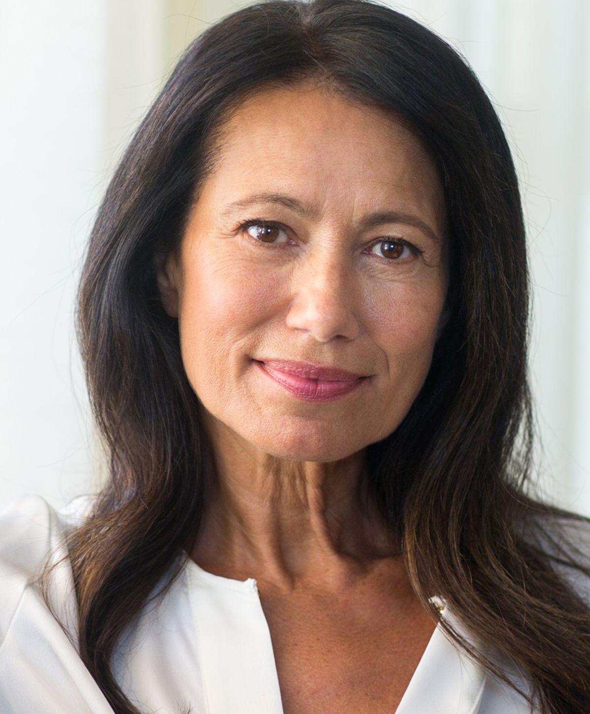 Middle-aged woman with long dark hair smiling.