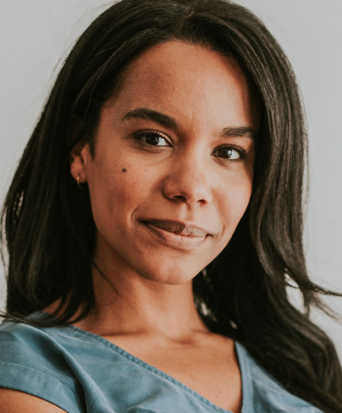 Woman with long hair smiling softly at camera.