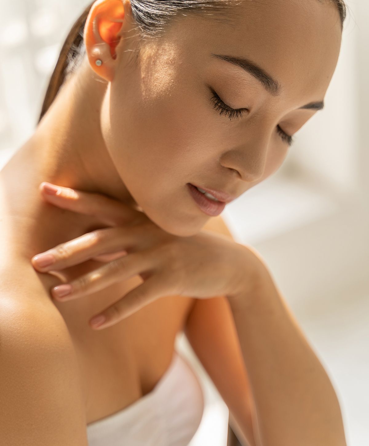 Woman with closed eyes, serene expression, soft light.