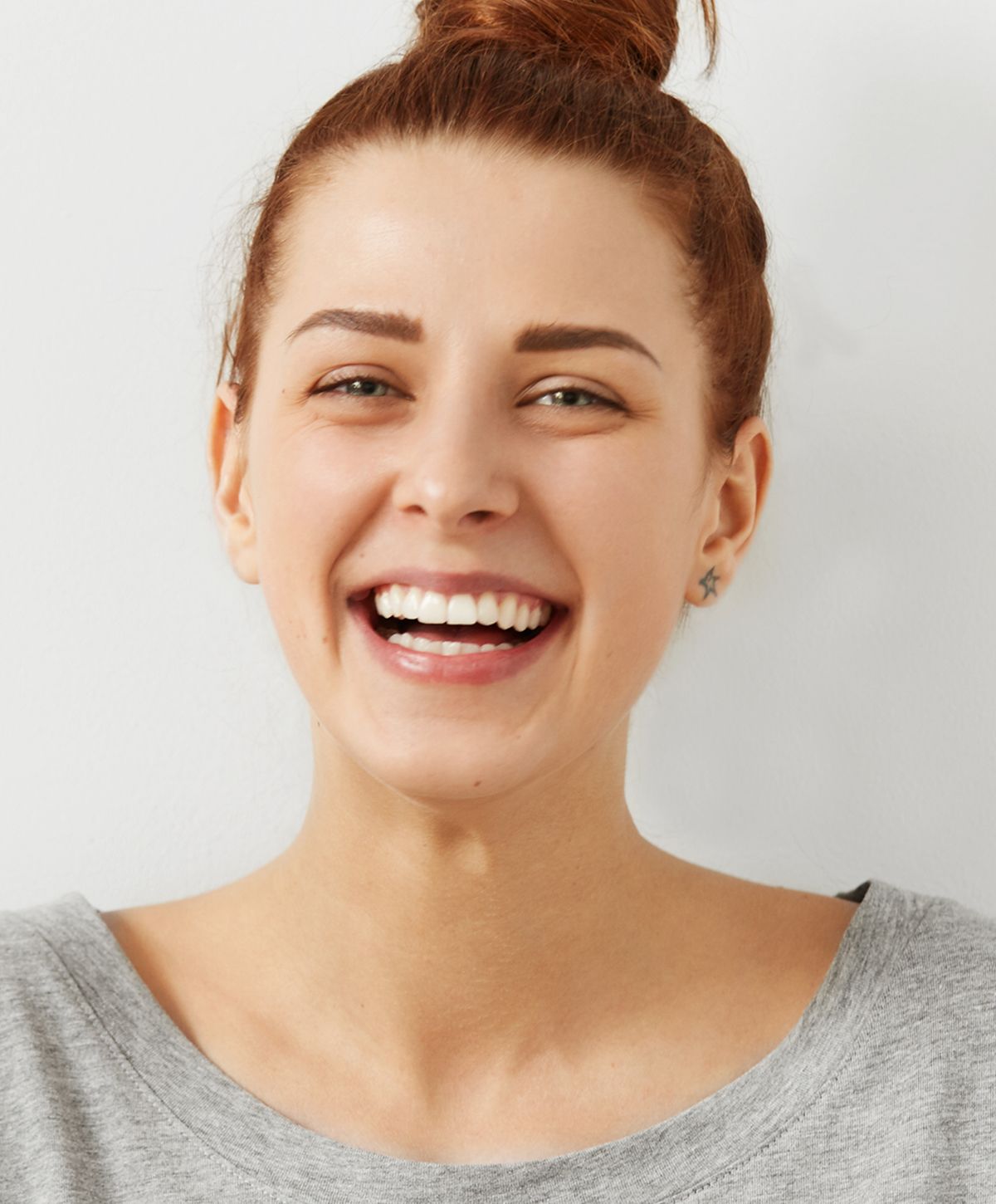 Smiling woman with brown hair in casual outfit.