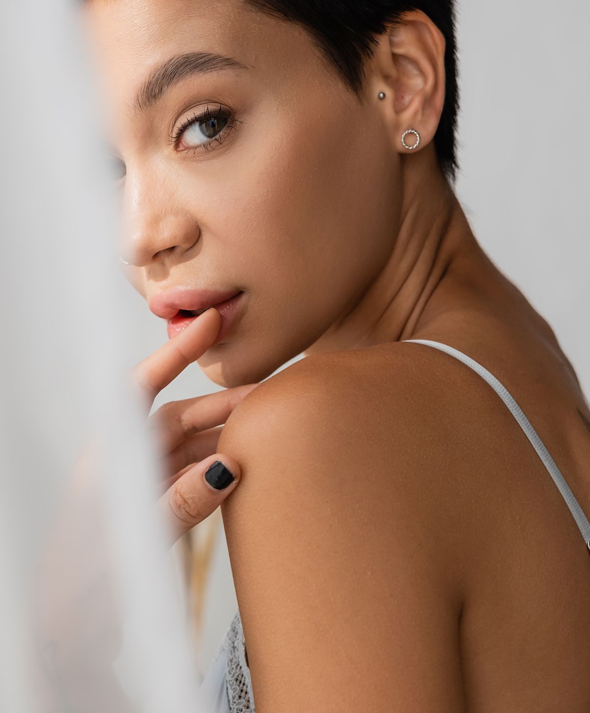 Woman with short hair and contemplative expression.