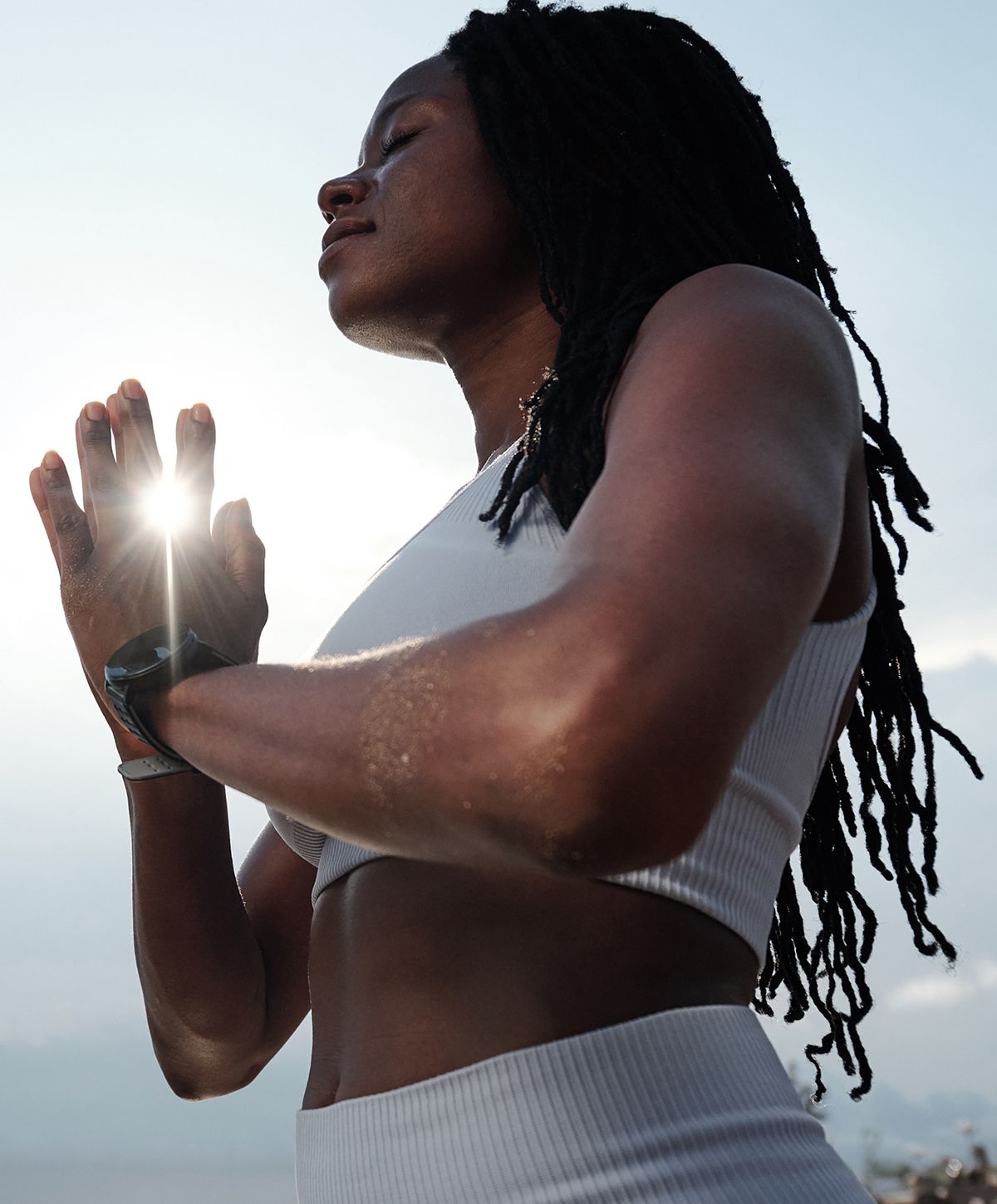 Woman practicing yoga with hands in prayer pose.