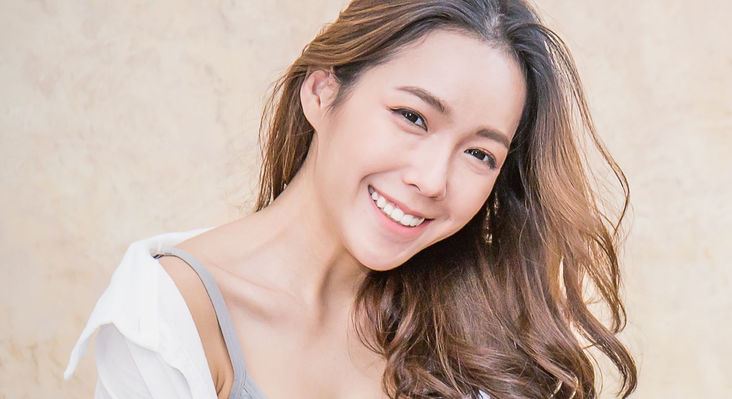Smiling woman with long hair and light background