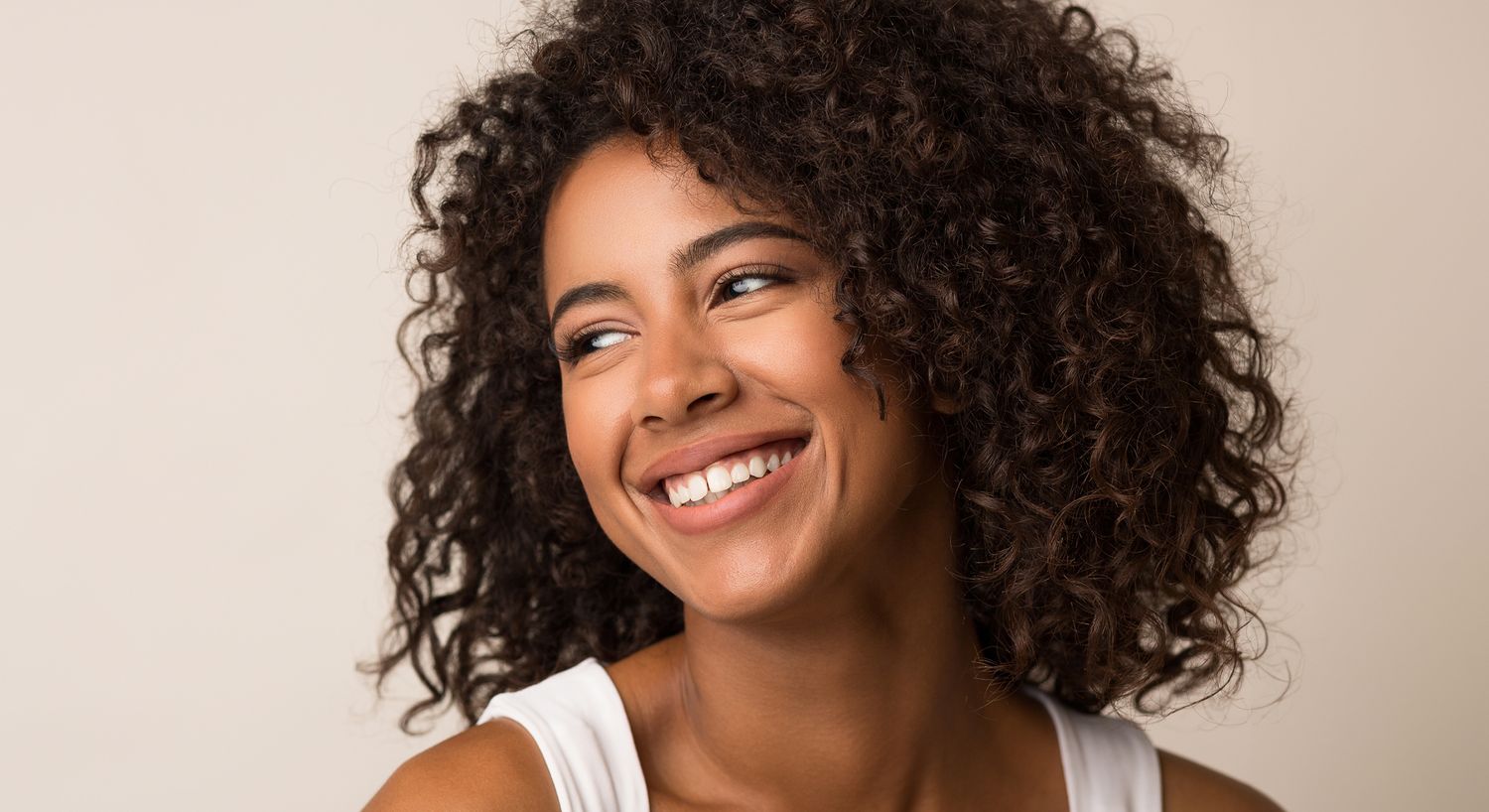 Smiling woman with curly hair and warm expression.